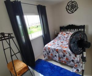 a bedroom with a bed and a fan and a window at Hostel bons sonhos Um Quarto uma Cama de Casal in Penha