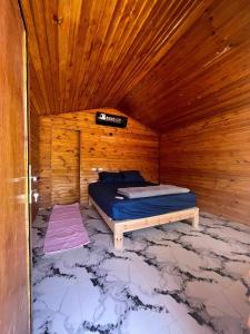 een slaapkamer met een bed in een houten kamer bij Full Moon Camp Sinai in Nuweiba