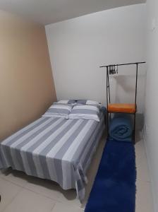 a small bedroom with a bed and a chair at Hostel bons sonhos Um Quarto uma Cama de Casal in Penha