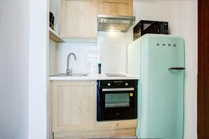 uma pequena cozinha com um frigorífico e um lavatório em Appartement T2 moderne avec terrasse clim parking et wifi - 4ALB3 em Perpignan