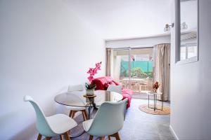 uma sala de estar com mesa e cadeiras em Appartement T2 moderne avec terrasse clim parking et wifi - 4ALB3 em Perpignan