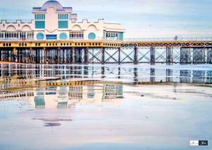 a pier on the water with chairs in the sand at Secluded High End 2BR in Southsea FREE parking in Portsmouth