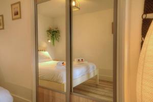 a mirror in a bedroom with a bed in it at Stunning Solent View Beachfront Apartment, Sleeps4 in South Hayling