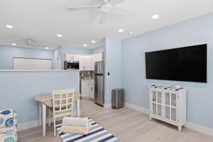 eine Küche mit einem Tisch und einem TV an der Wand in der Unterkunft Captain Ed's - Charming Studio at PalmView of Sanibel with Bikes in Sanibel