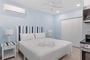a white bedroom with a large white bed with two towels at Captain Ed's - Charming Studio at PalmView of Sanibel with Bikes in Sanibel