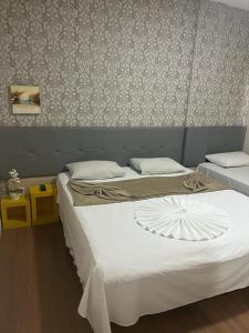 2 aparte bedden in een kamer met een muur bij Hotel Treviso in Linhares