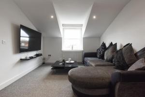 a living room with a couch and a flat screen tv at Spacious 2 Bedroom Flat with Parking in Portsmouth