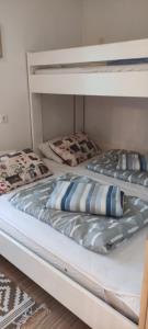 - deux lits superposés installés l'un au-dessus de l'autre dans l'établissement Planika B&M, à Bohinj