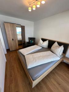 1 dormitorio con 1 cama grande y suelo de madera en Sonnseit 21, en Grossarl