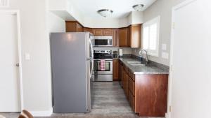 a kitchen with wooden cabinets and a refrigerator at Updated Condo in A Old Town Scottsdale Location in Scottsdale