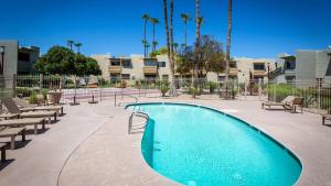 uma piscina num pátio com bancos e palmeiras em Updated Condo in A Old Town Scottsdale Location em Scottsdale