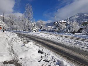 a road covered in snow next to a street at Trigon Villa Family , HOT POOL ,SAUNA,JACUZZI in Gabala