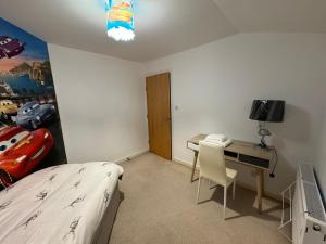 a bedroom with a bed and a desk with a computer at 23 Lochburn Gardens - Carz in Maryhill