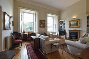 a living room with white furniture and a fireplace at Naval Officers Quarters Flat in Gosport