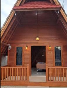 a large wooden house with a porch and a balcony at HomeStay "Sakinah" Syariah AC in Sarilamak +4 photos