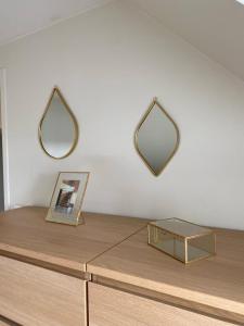 een tafel met twee spiegels op een witte muur bij bel appartement tout juste rénové 4 personnes in Vierzon