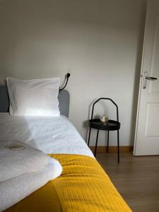 een slaapkamer met een bed met een gele deken en een tafel bij bel appartement tout juste rénové 4 personnes in Vierzon
