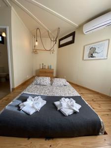 1 dormitorio con 1 cama grande y 2 toallas en YMCA Camp Alambre, en Azeitão