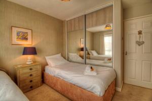 a bedroom with two beds and a mirror at Modern 2BR w sea views beach access in South Hayling