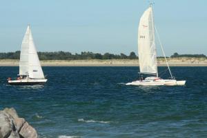 two sailboats floating in the water near a beach at Modern 2BR w sea views beach access in South Hayling