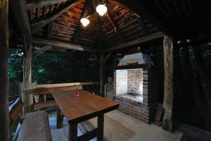 a wooden table and a brick oven in a pavilion at Apartment Drvena kuca Mreznica in Gornji Zvečaj