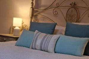 łóżko z niebiesko-białymi poduszkami w obiekcie La Morada de Toledo w mieście Toledo
