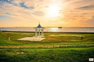 a gazebo in the grass next to the water at Centrally Located 3Bed Family Home in Portsmouth