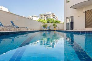 a swimming pool with blue water in a building at Xtay Privilege Botafogo - Apartamentos a 6min da praia e próximo a Copacabana in Rio de Janeiro