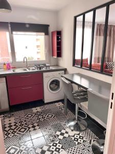 a kitchen with a sink and a washing machine at Le Duplex Paris Basilique Stade de France in Saint-Denis