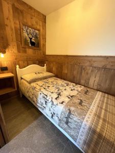 1 dormitorio con 1 cama en una habitación con paredes de madera en Maison Meynet Mountain Charm en Breuil-Cervinia