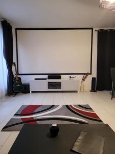 a large projection screen in a room with a rug at Duplex proche Disney avec écran cinéma in Chessy