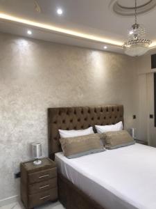 ein Schlafzimmer mit einem großen Bett und einem Nachttisch in der Unterkunft Ferienwohnung mit Meerblick in Al Hoceïma