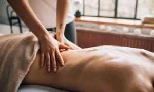 a woman getting a back massage from a massage therapist at Selva Maria Tayrona's Hostel in Santa Marta