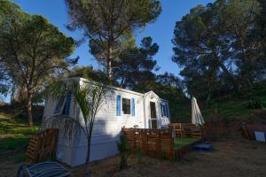 a small white caravan with a porch and a umbrella at ZALUAY - Mobile Homes in Isla Cristina