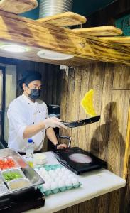 Knight Armour Hotel في دبي: شيف واقف في مطبخ يحضر طعام