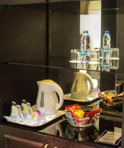 Knight Armour Hotel في دبي: كونتر فيه صحنين وزجاجات ماء