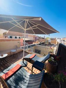 a patio with two chairs and an umbrella on a roof at Riad Atlas Toyours in Marrakesh
