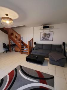 a living room with a couch and a table at Duplex proche Disney avec écran cinéma in Chessy