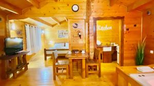 a living room with a table and a tv in a cabin at פינה ברמות - צימרים לנוף הכנרת in Moshav Ramot