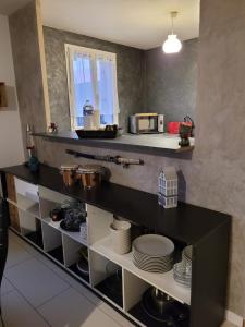 a kitchen with a counter with plates and a microwave at Duplex proche Disney avec écran cinéma in Chessy +13 photos