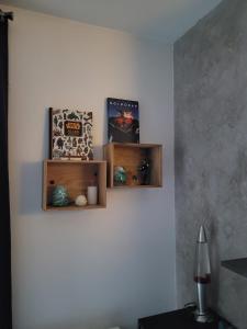 a wall with two wooden shelves on a wall at Duplex proche Disney avec écran cinéma in Chessy