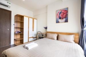 um quarto com uma grande cama branca e uma cabeceira em madeira em 1st district - best price/two bedrooms apartments - the SOHO em Ho Chi Minh