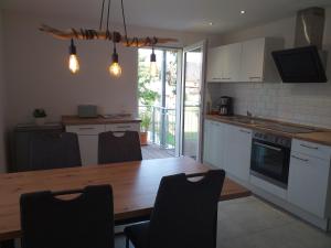 a kitchen with a wooden table and a dining room at Kleine Auszeit in Rust