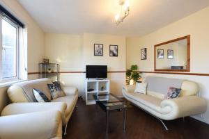 ein Wohnzimmer mit 2 Sofas und einem TV in der Unterkunft Minutes from Dockyard Homely 2bed apt sleeps 6 in Portsmouth