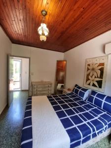 een slaapkamer met een blauw en wit bed en een houten plafond bij Acutí Departamento in Puerto Iguazú