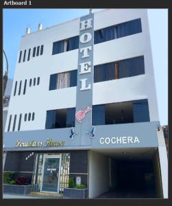 a white building with a sign that reads hotel at Hotel Peruvians House in Lima