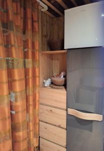 uma cozinha com um armário de madeira e um micro-ondas em PIE OPĪŠA em Cēsis