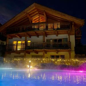 un grand bâtiment avec une terrasse au-dessus d'une piscine la nuit dans l'établissement Luxus Chalet - Zentral - Poolblick mit Sauna, à Seefeld in Tirol