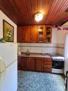 een keuken met houten kasten en een witte koelkast bij Acutí Departamento in Puerto Iguazú