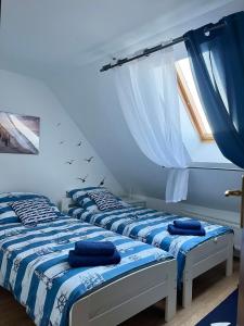 two beds in a room with two windows at Apartament Ustronie Leśne in Międzyzdroje